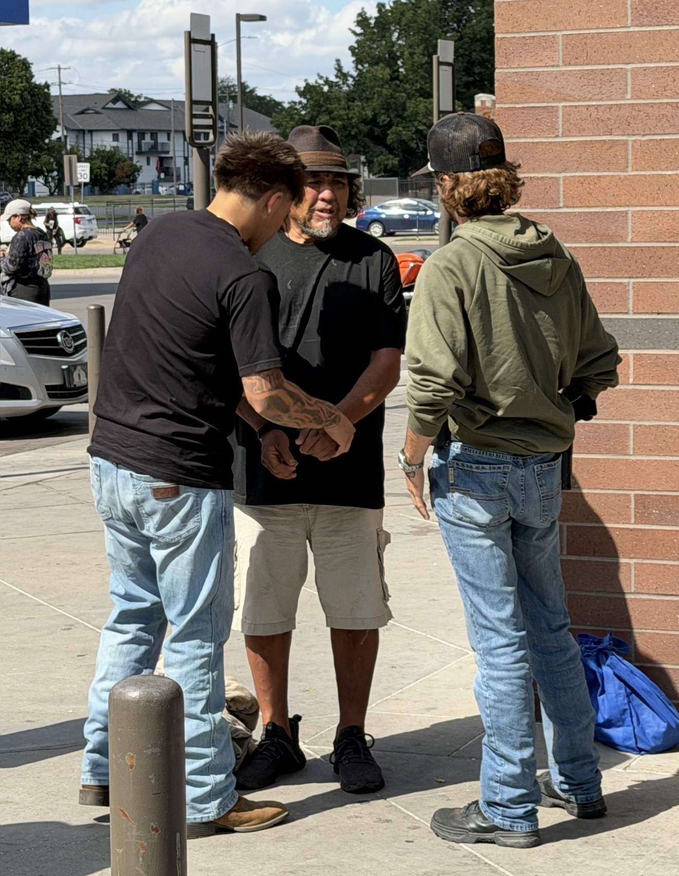 Three people standing together on a city sidewalk