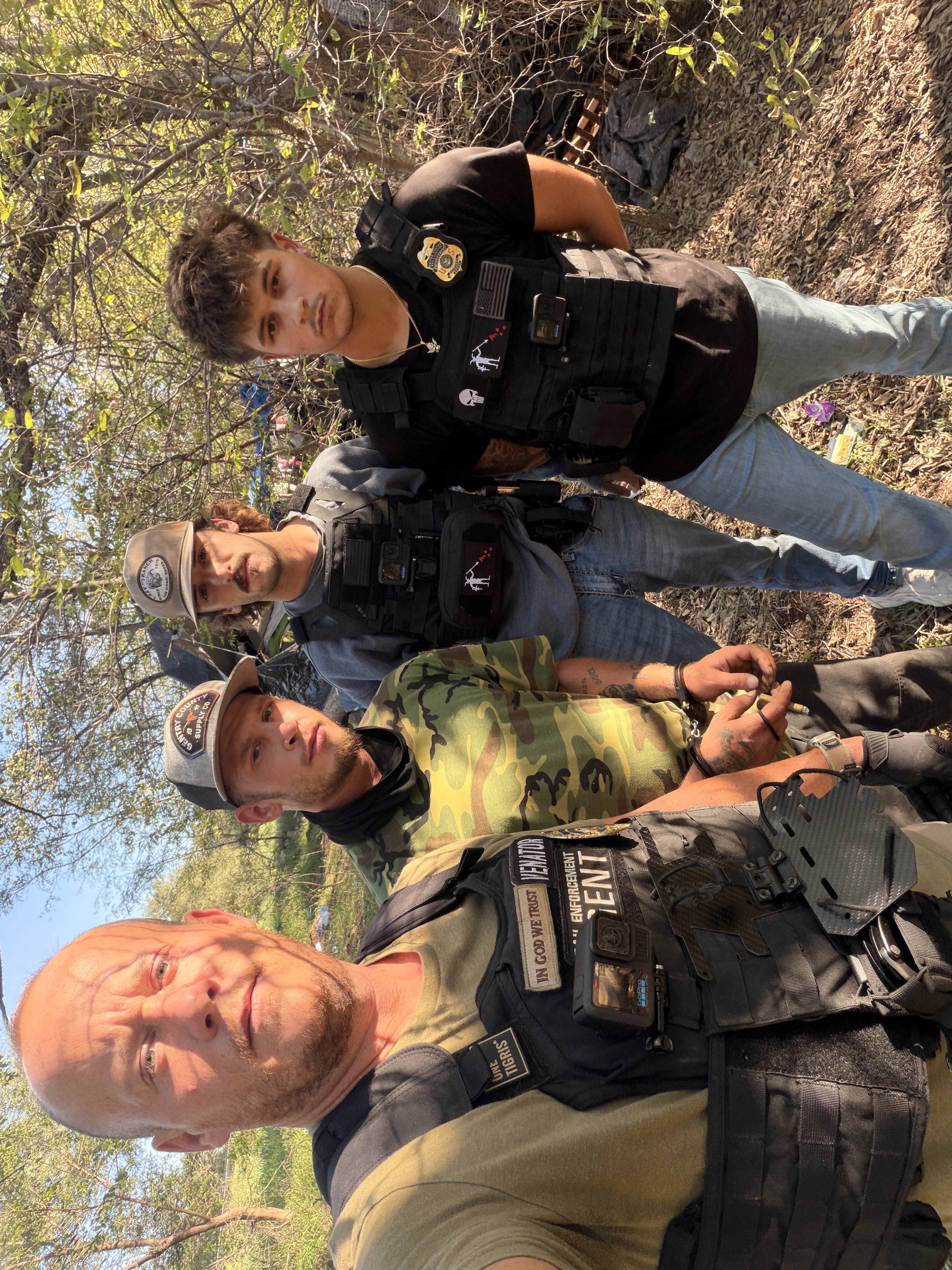A group photographed outdoors in a wooded area